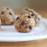 Chocolate chip energy balls with oats on a white plate.
