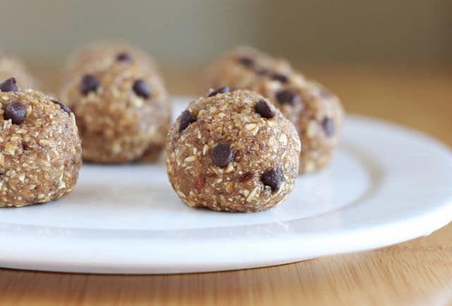 Chocolate chip energy balls with oatmeal on a white plate.