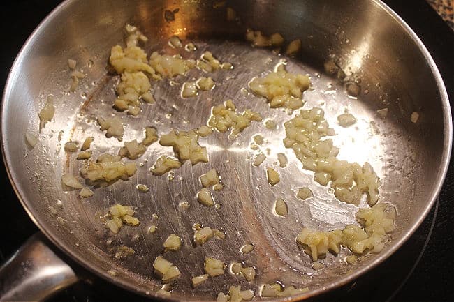 Onion and garlic sauteing in a pan.