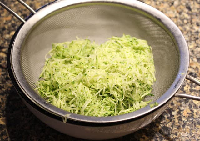 Grated zucchini in a sieve.