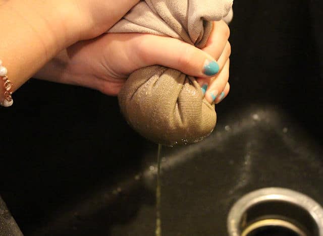 Squeezing the water out of grated zucchini.