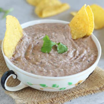 Bowl of hummus with tortilla chips.