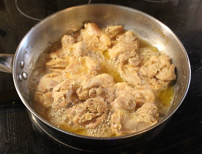 Chicken thighs in a steel pan.