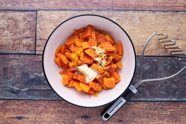 Sweet potato cubes and butter in a bowl.