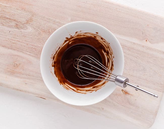 Whisking a bowl of melted chocolate.