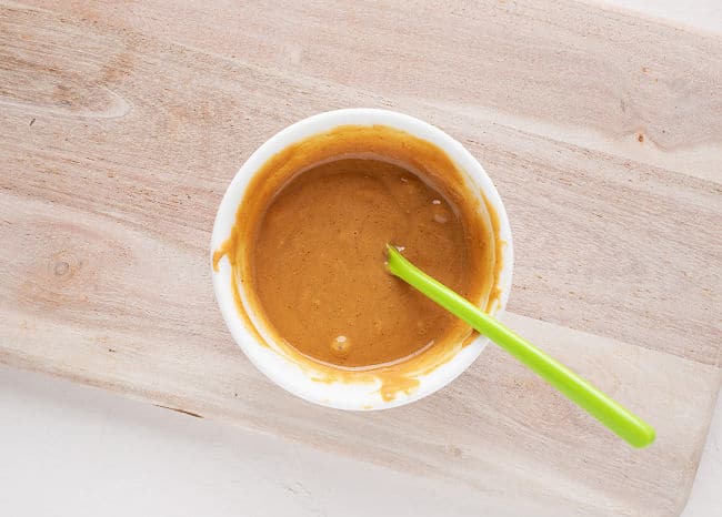 Stirring a bowl of peanut butter and coconut oil.