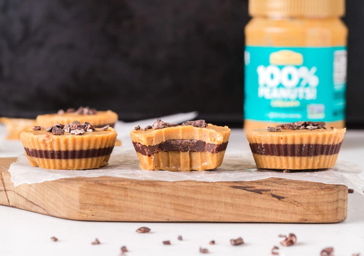 Three peanut butter cups on a small wood board.