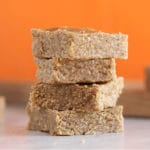 Almond butter bars with an orange background.