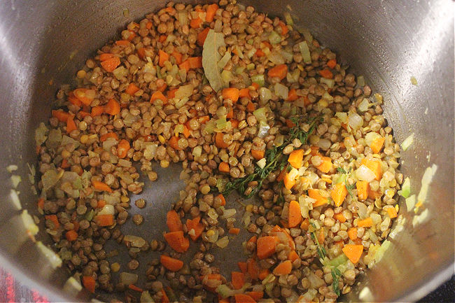 Dried lentils and vegetables in a large pot.