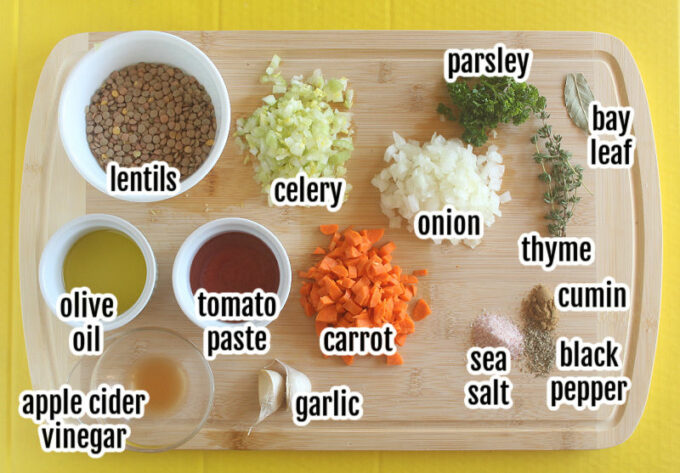 Various ingredients laid out on a table, including lentils, vegetables, and tomato paste.