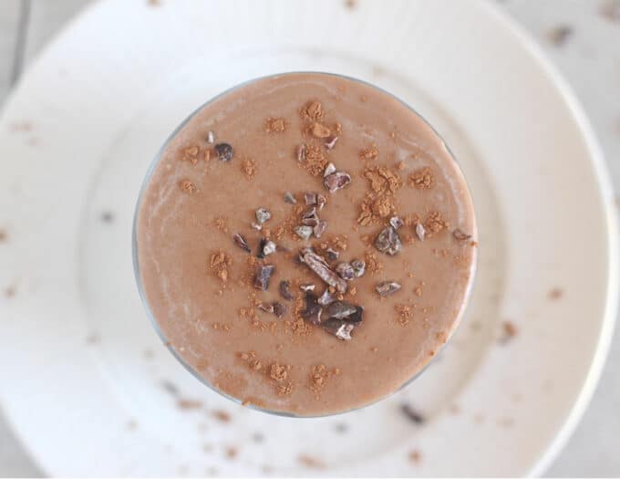 Top down view of a chocolate smoothie with cacao nibs on top.