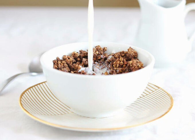 Milk being poured on top of chocolate granola.