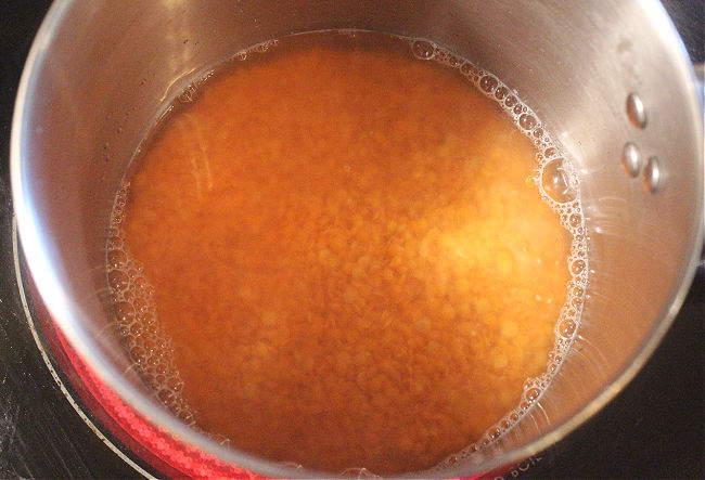 Lentils soaking in a pot of water.