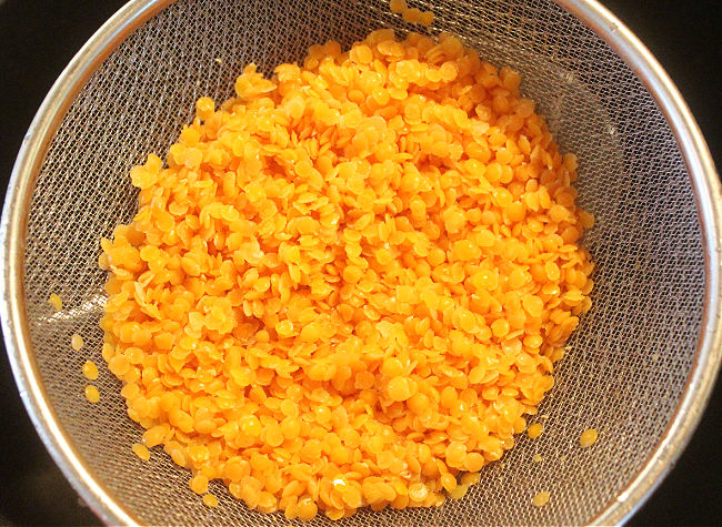 Red lentils in a steel sieve.