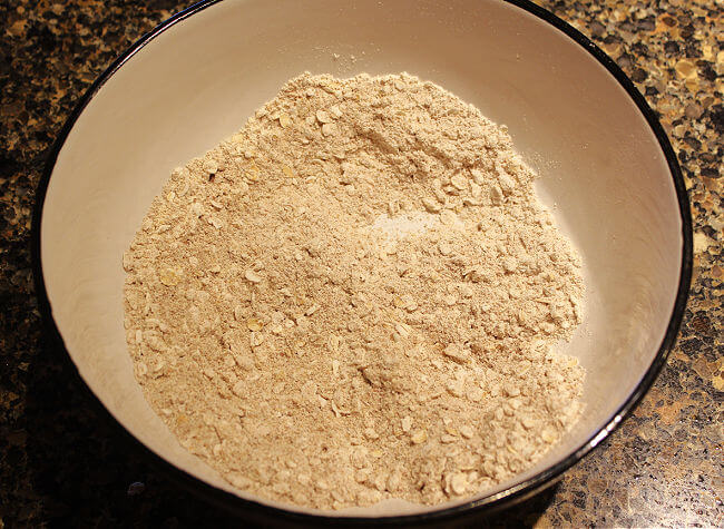 Flour and oats in a large white bowl.