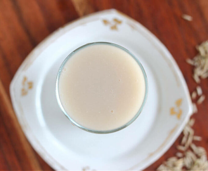 Overhead shot of a glass of rice milk on a white plate.