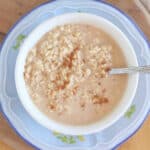 Oatmeal and milk in a bowl on a plate.