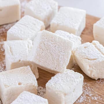 Large marshmallows laid out on a cutting board.