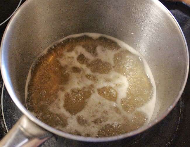 Honey syrup simmering in a pot.