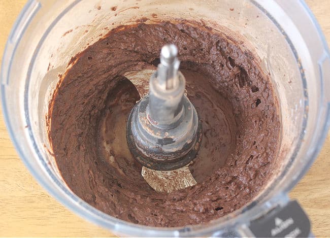 Thick brownish-black batter in a food processor.