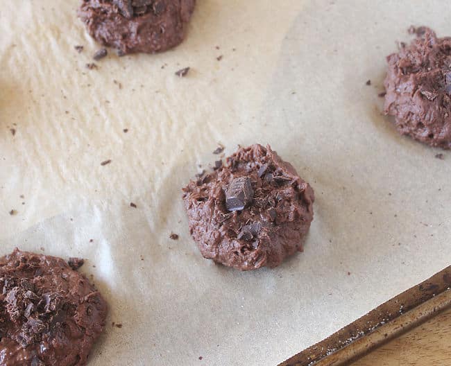 Unbaked chocolate cookie on a baking sheet with parchment paper.