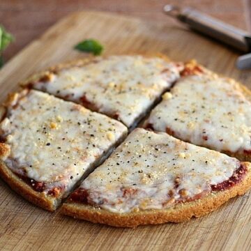 Four slices of quinoa pizza crust on a board.