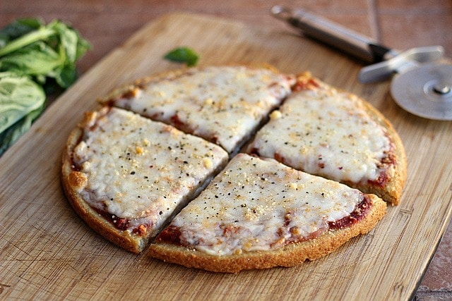 Four slices of quinoa pizza crust on a board.