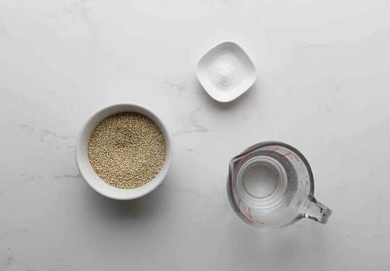 Quinoa, salt, and water on a table.