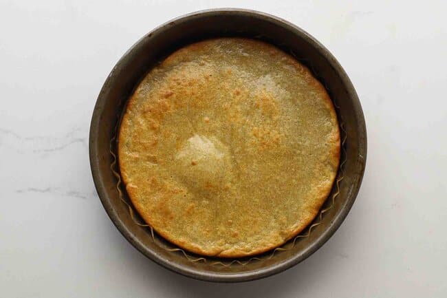 Baked pizza crust in a cake pan.