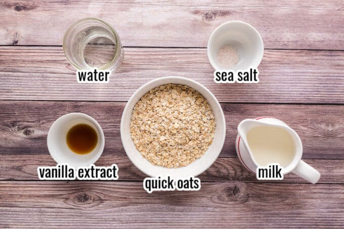 Oats, milk, water, salt, and vanilla laid out on a table.