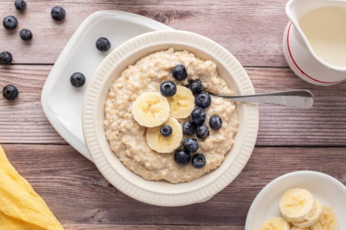 Bowl of oatmeal with blueberries and banana slices.