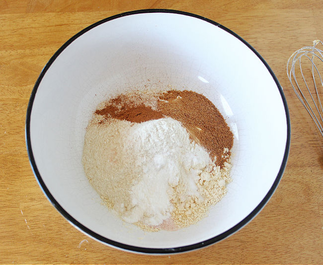 Flour, sugar, and baking powder in a large white bowl.