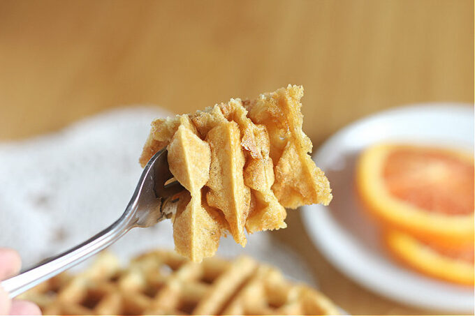 Close-up of a fork full of waffles.