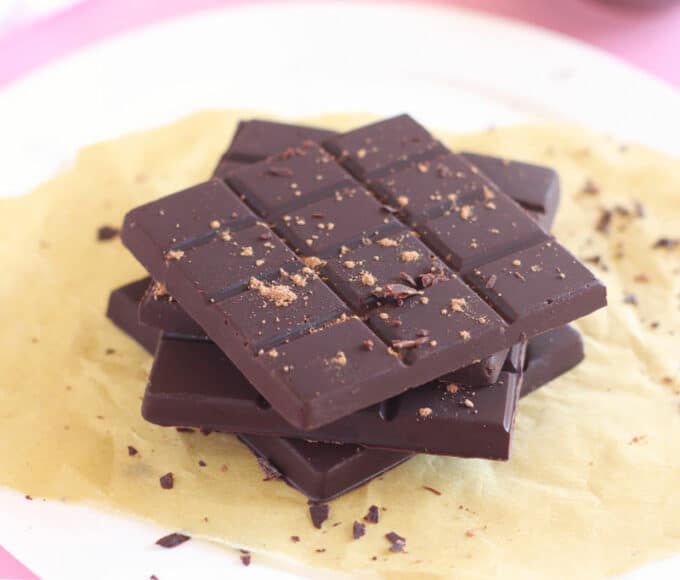 Small stack of chocolate bars on a parchment paper-lined plate.