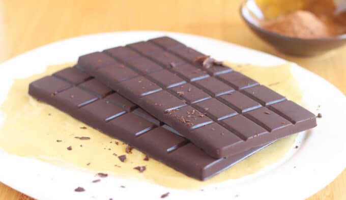 Two whole chocolate bars on a white plate.