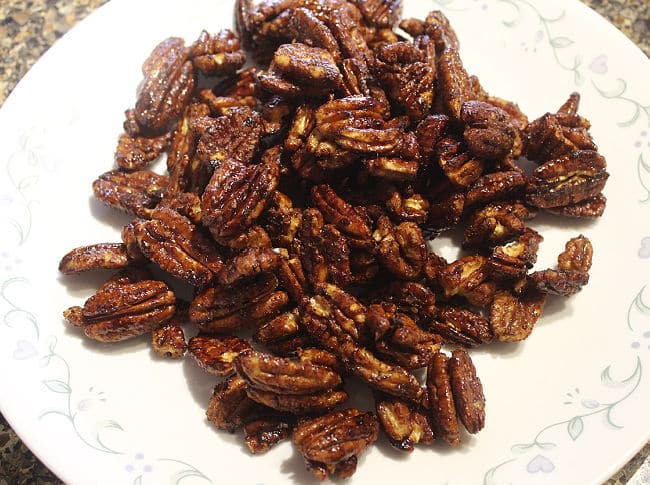 Candied pecans on a white plate.