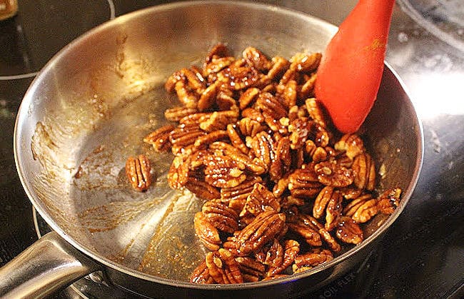 Sticky pecans in a stainless steel pan.
