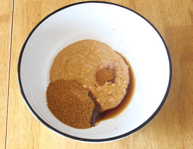 Peanut butter, coconut sugar, cinnamon, and vanilla in a large white bowl.
