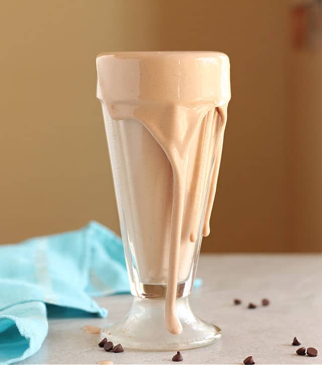 Overflowing chocolate frosty in an ice cream glass.