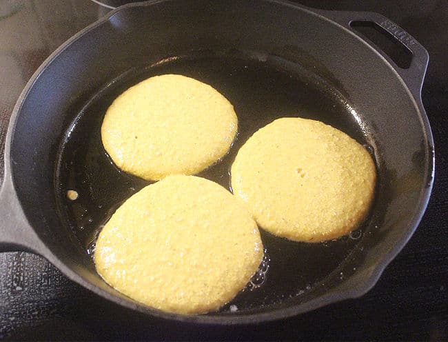 Three pancakes in a cast iron skillet.