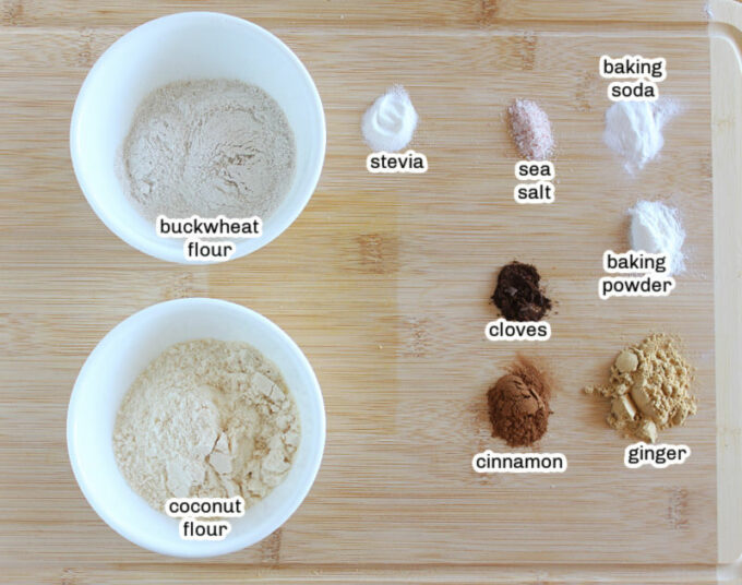 Flours and spices on a wood cutting board.