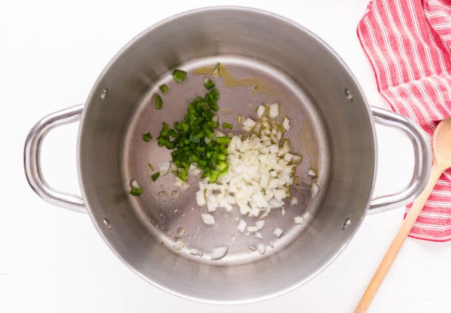 Sauteing onion and green bell pepper in a large pot.