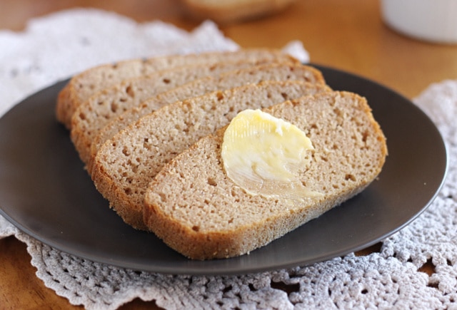 Slices of gluten-free bread on a dark plate.