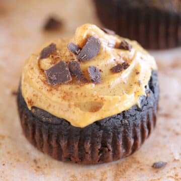 Chocolate muffin topped with peanut butter frosting and chocolate chips.