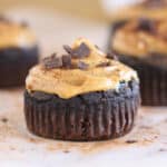 Chocolate muffin topped with peanut butter and chopped chocolate.