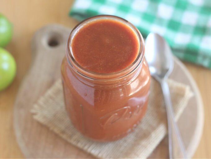 Top down view of a glass jar of enchilada sauce.