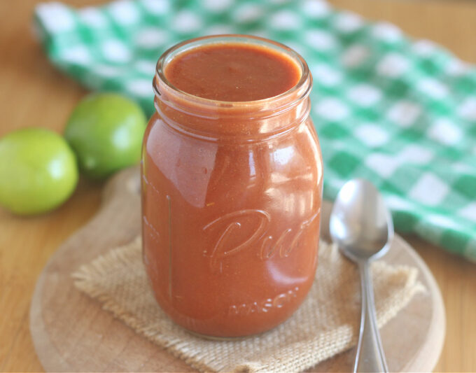 Side view of a glass jar of enchilada sauce.