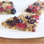 Oat flour flatbread with berries on a white plate.