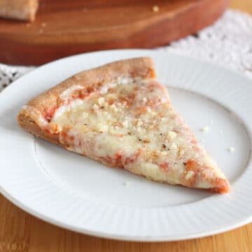 Slice of cheese pizza on a white plate.