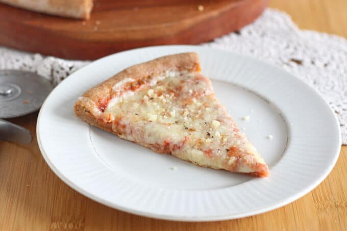 Slice of cheese pizza on a white plate.
